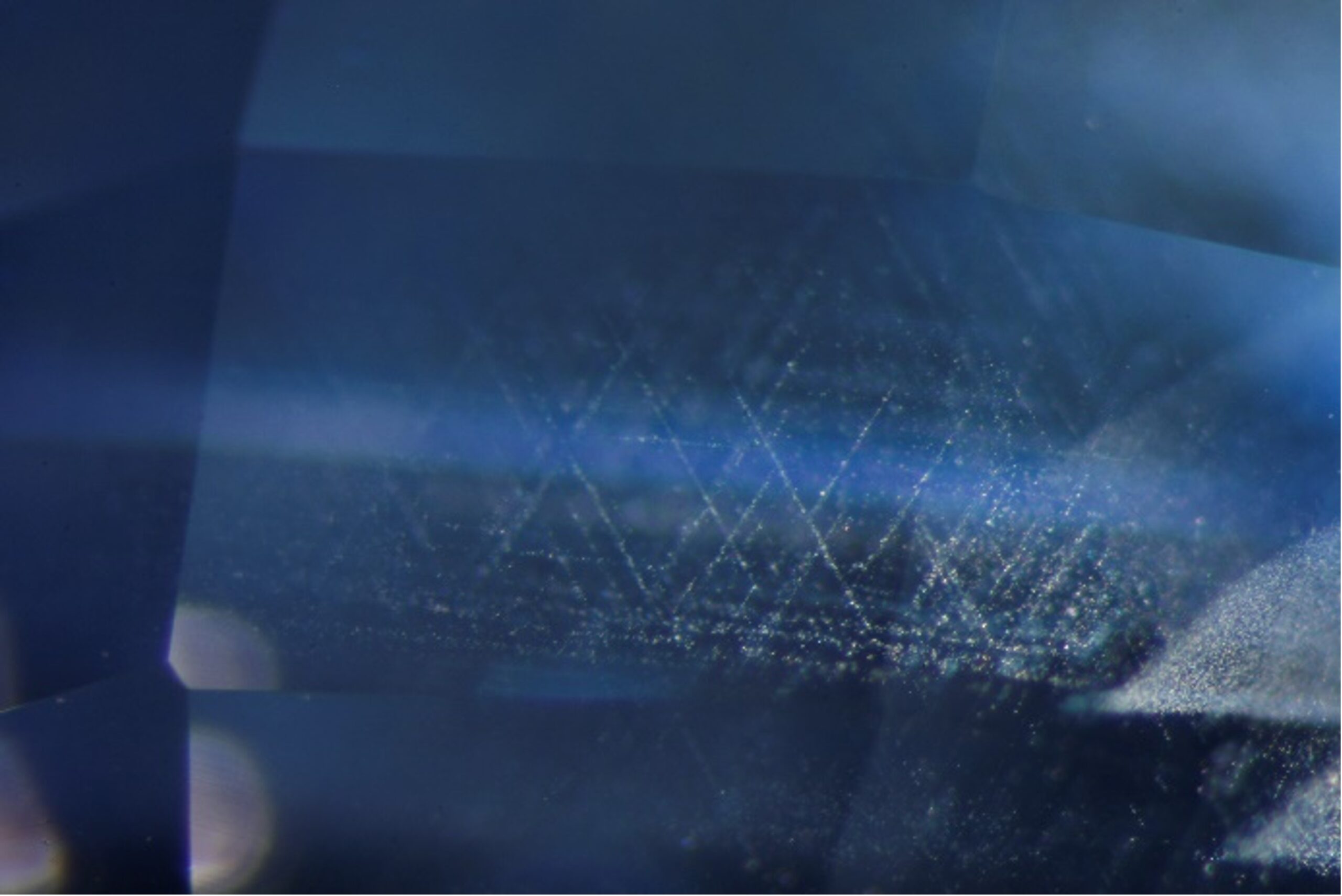 “Punsiri heated” blue sapphire, visible with fibre optic lighting present is dissolved silk. Darkfield
& fibre optic light, FOV 2.2 mm: Photomicrograph by Sarocha Luetrakulprawat
Taken by ICA- GemLab 
