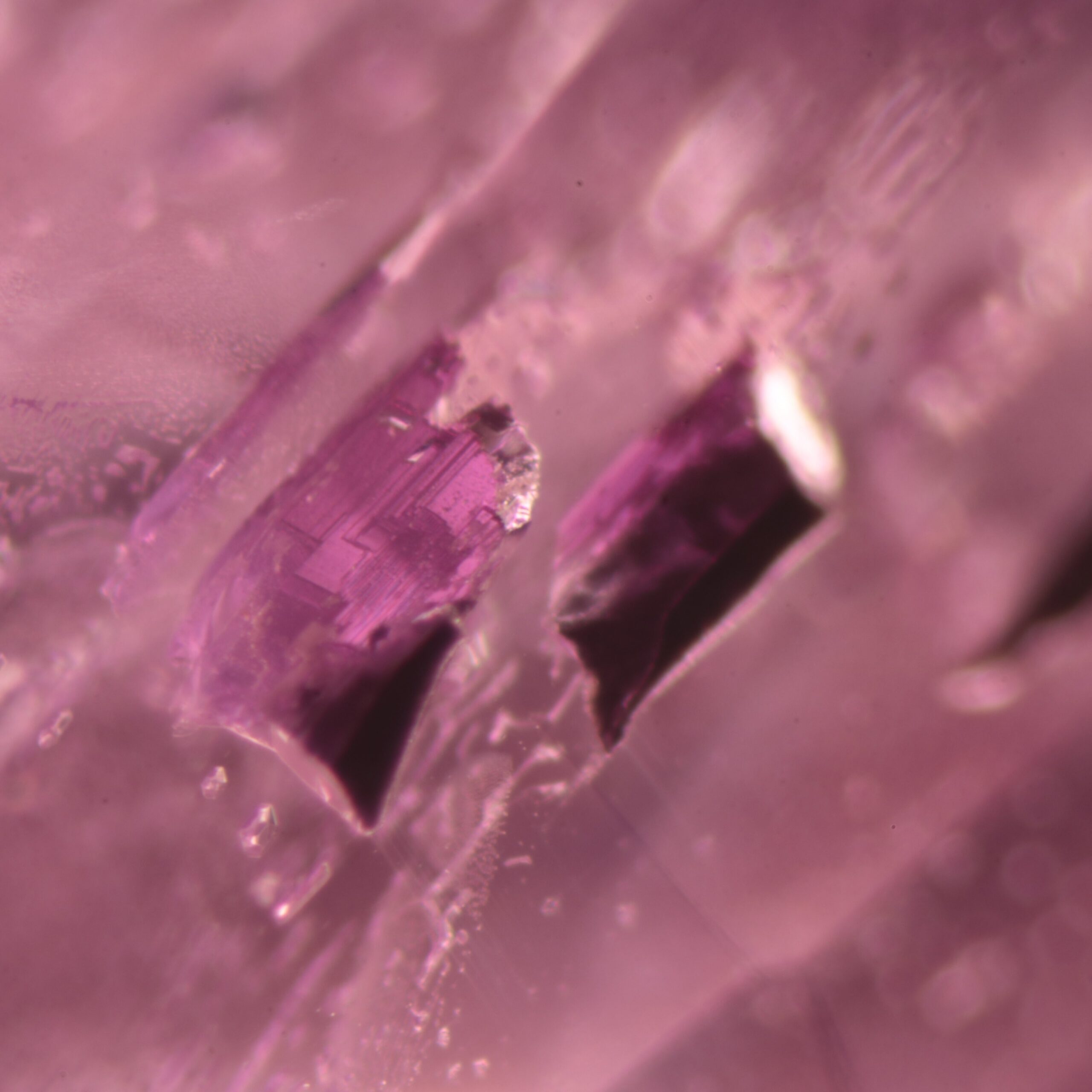 Magnified sharply edged crystal inclusions in natural pink sapphire