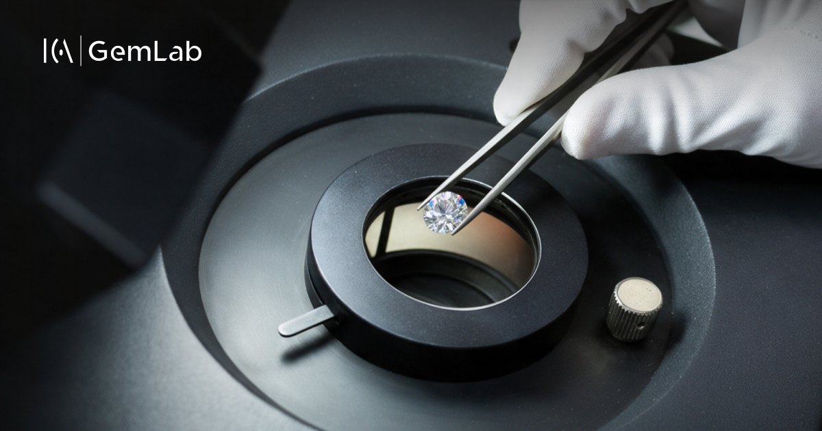 A round diamond held in tweezers over a gemological microscope at ICA | GemLab